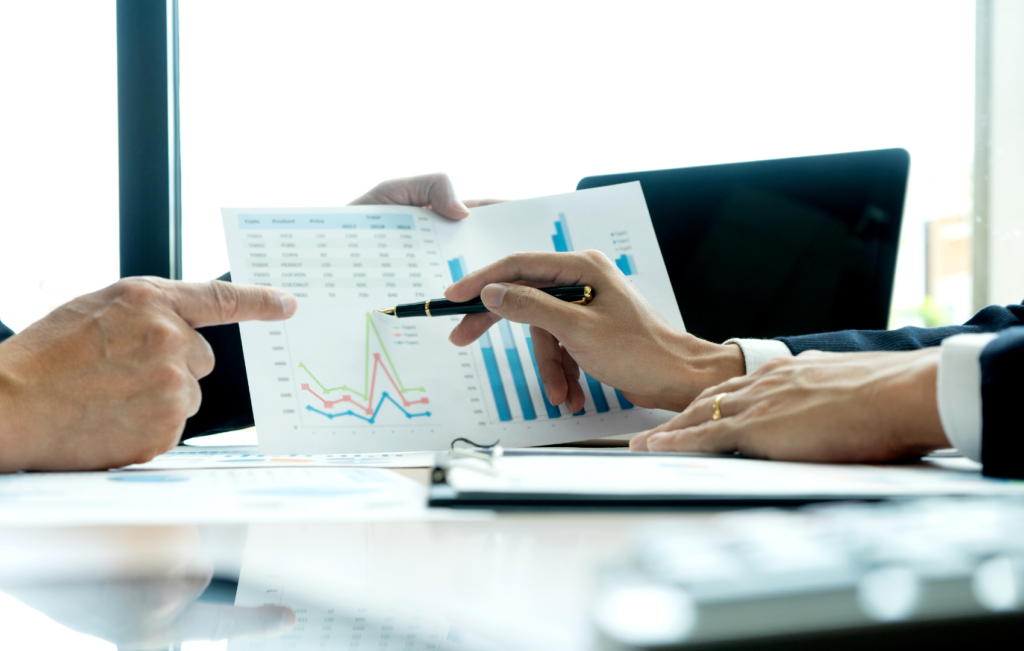 men's hands pointing at chart with pen